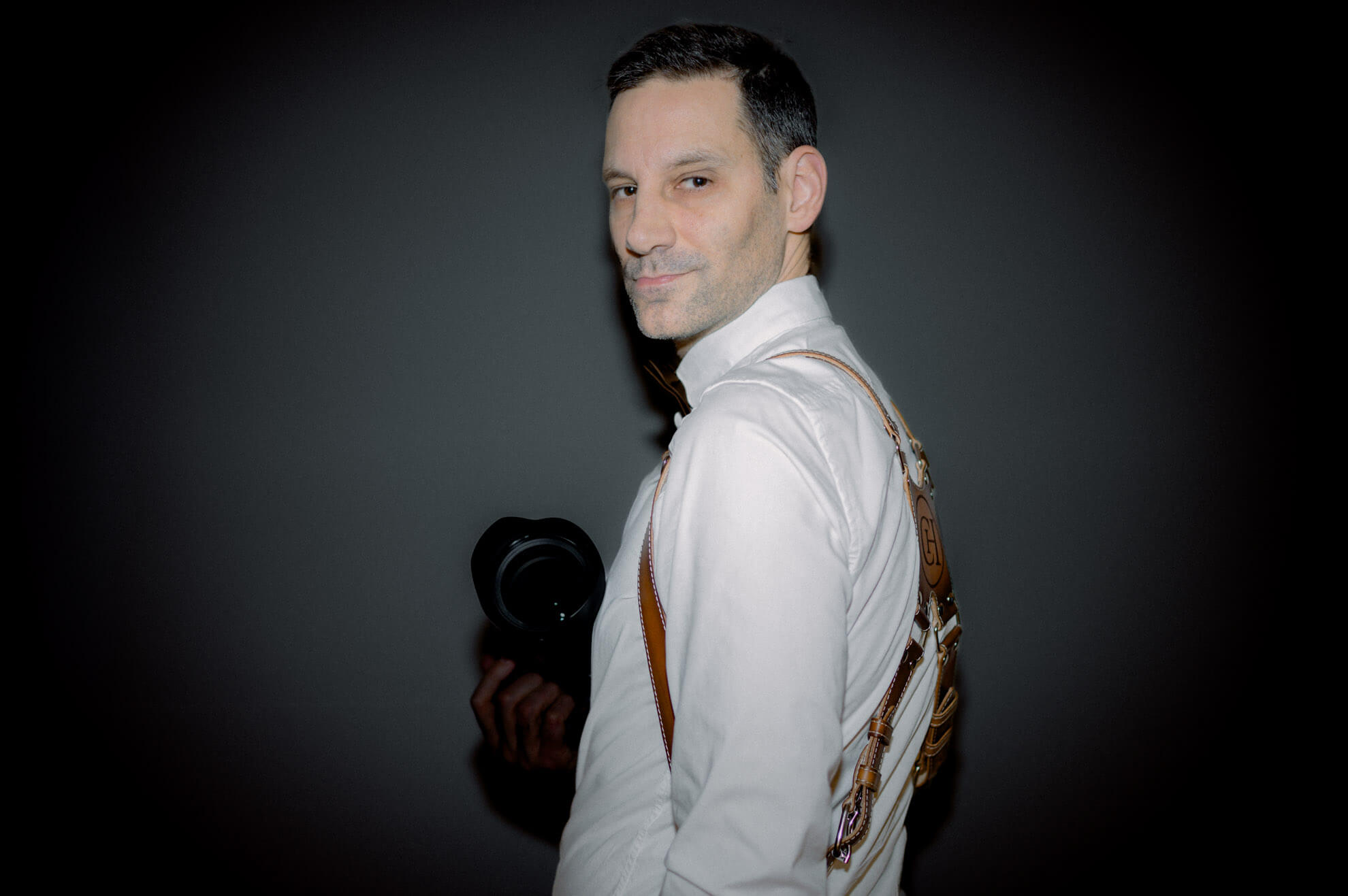 David Rickenbach mit Kamera und Lederharness – Portrait eines ruhigen Hochzeitsfotografen aus der Schweiz.