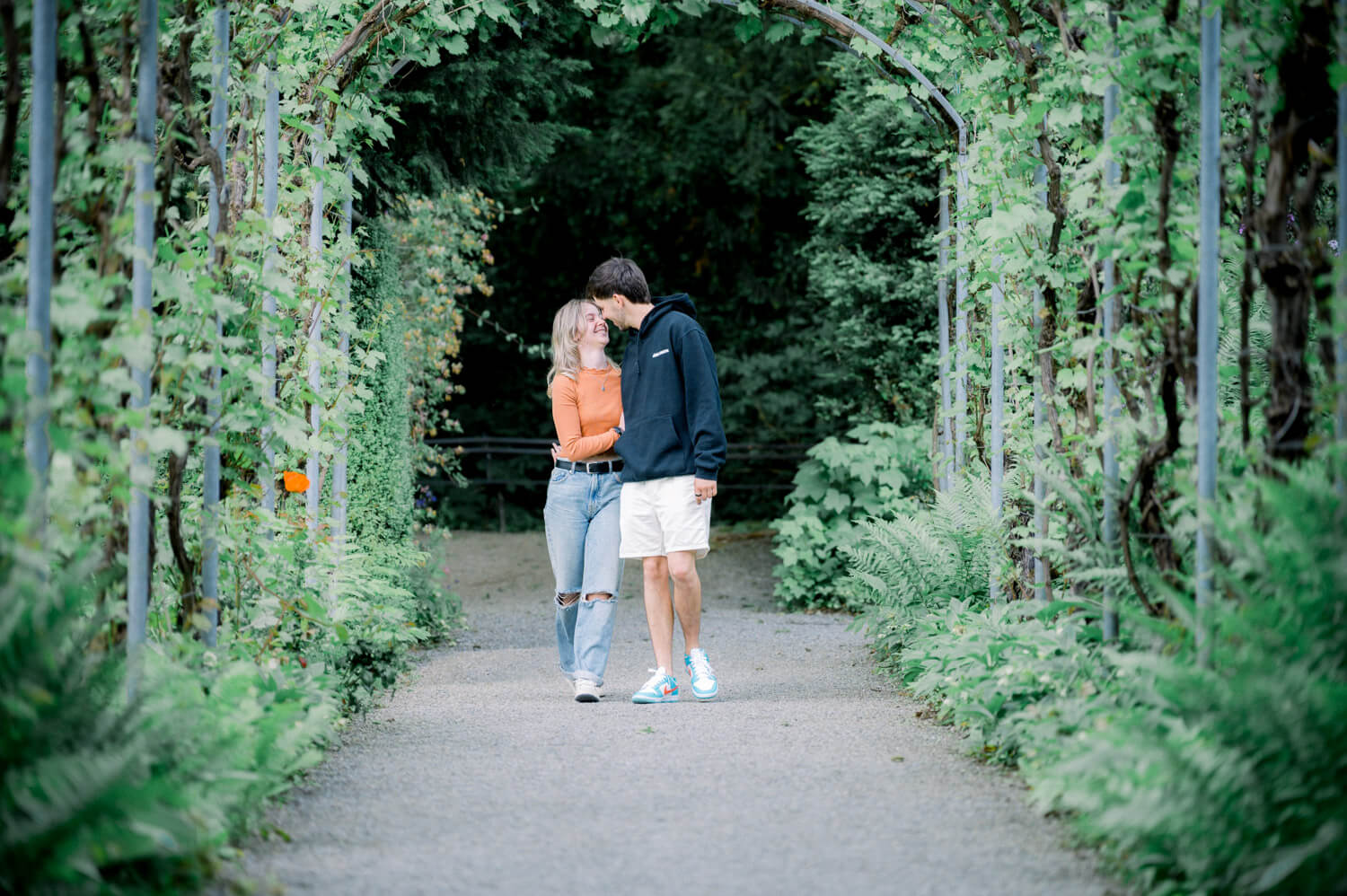 Paar spaziert durch grünen Garten bei Engagement Shooting