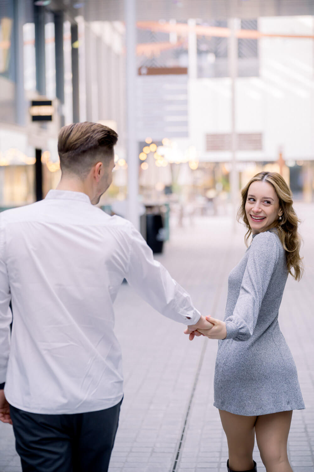 Frau blickt beim Gehen lächelnd zu ihrem Partner zurück