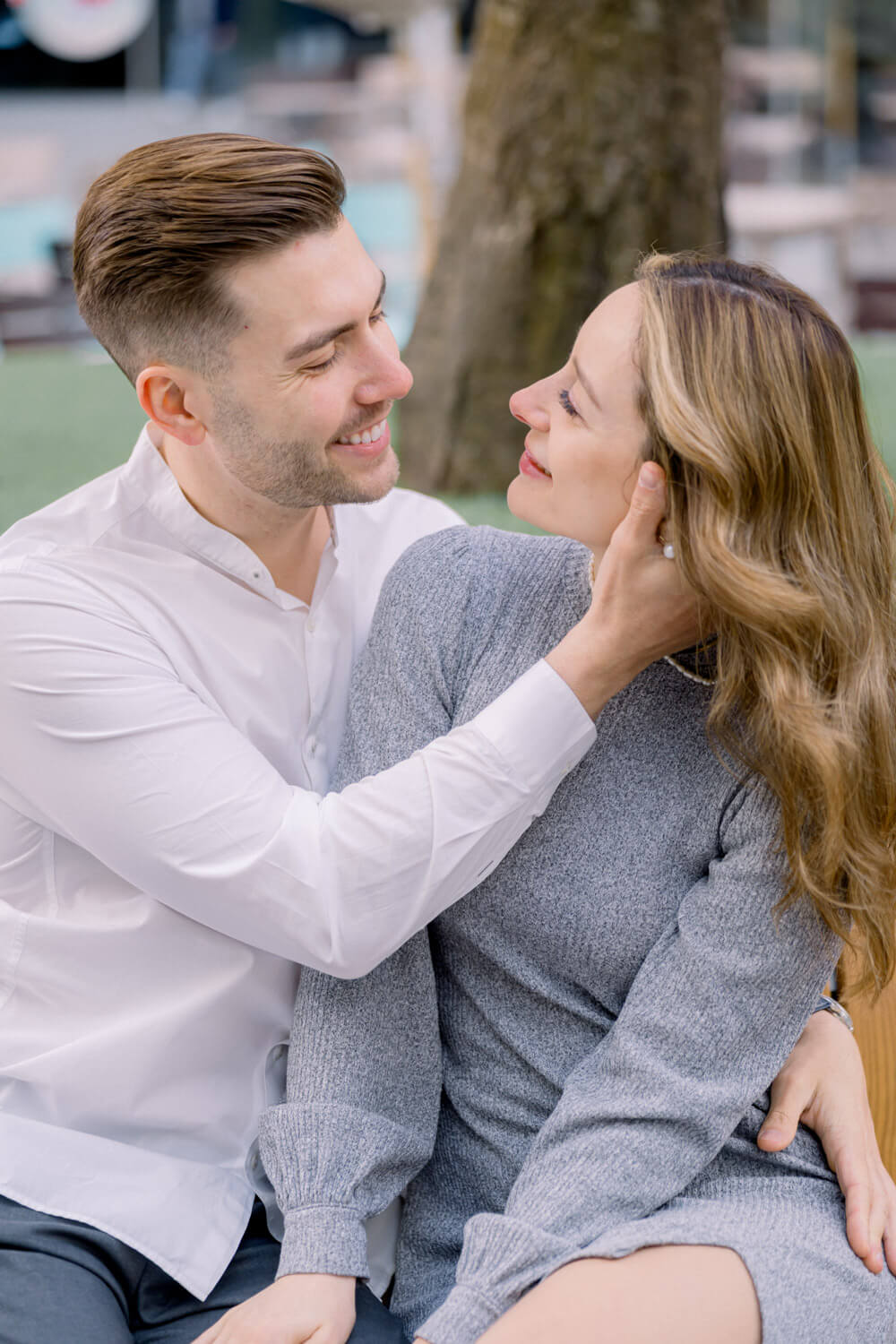 Paar sitzt nah beieinander und lacht gemeinsam