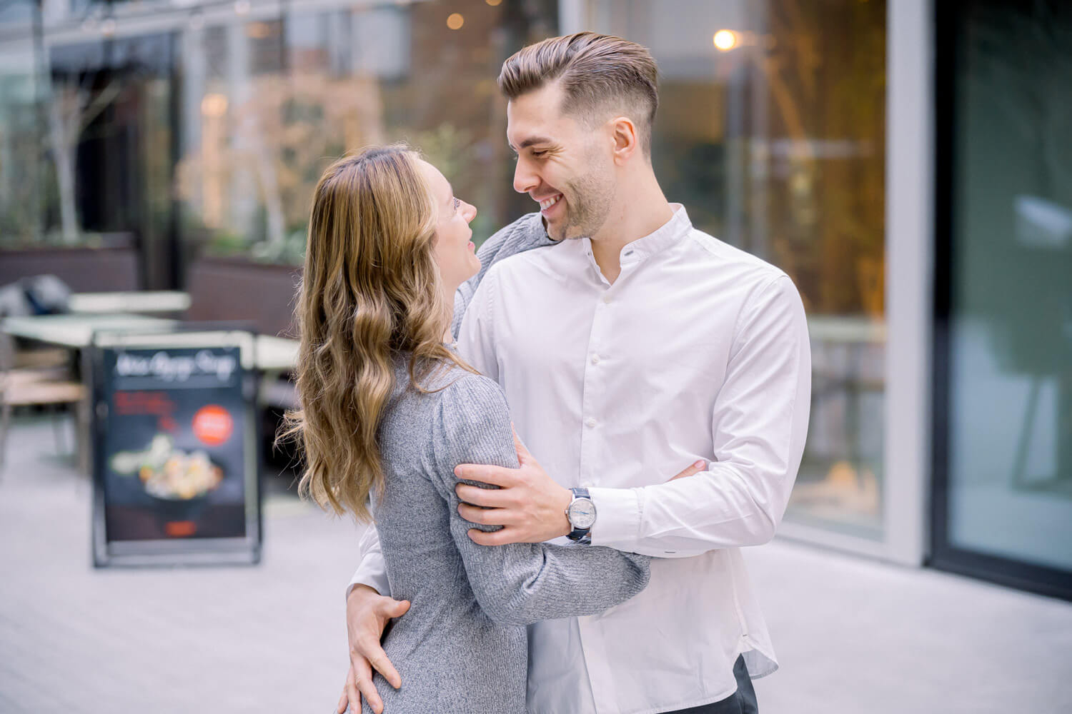 Paar in einer natürlichen Umarmung vor moderner Architektur