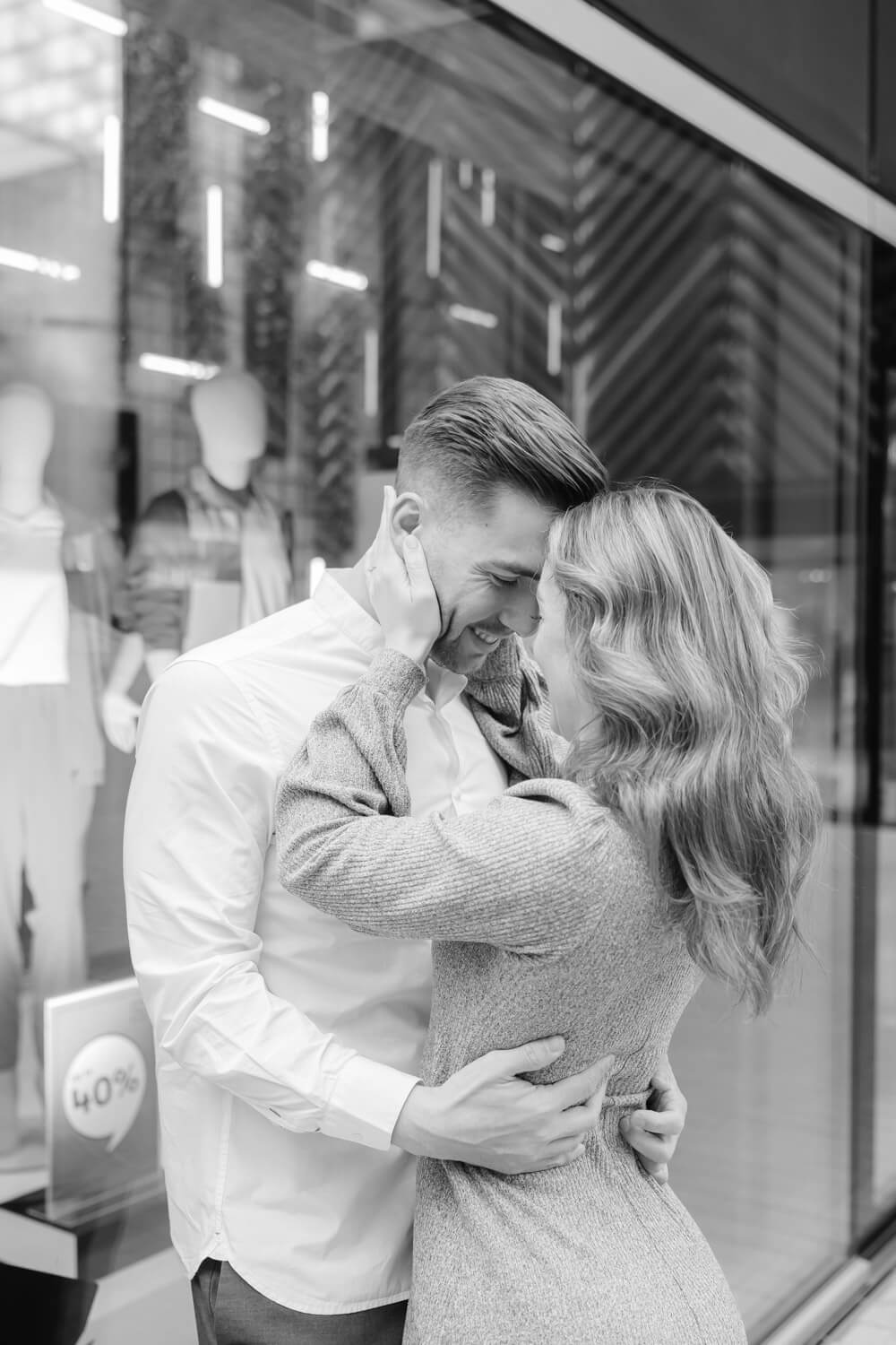 Schwarzweiss-Aufnahme eines Paares in enger Umarmung im urbanen Umfeld