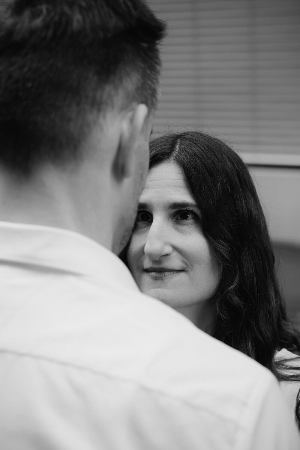 Intimer Moment zwischen Paar mit ruhigem Blickkontakt in urbaner Umgebung in Schwarzweiss