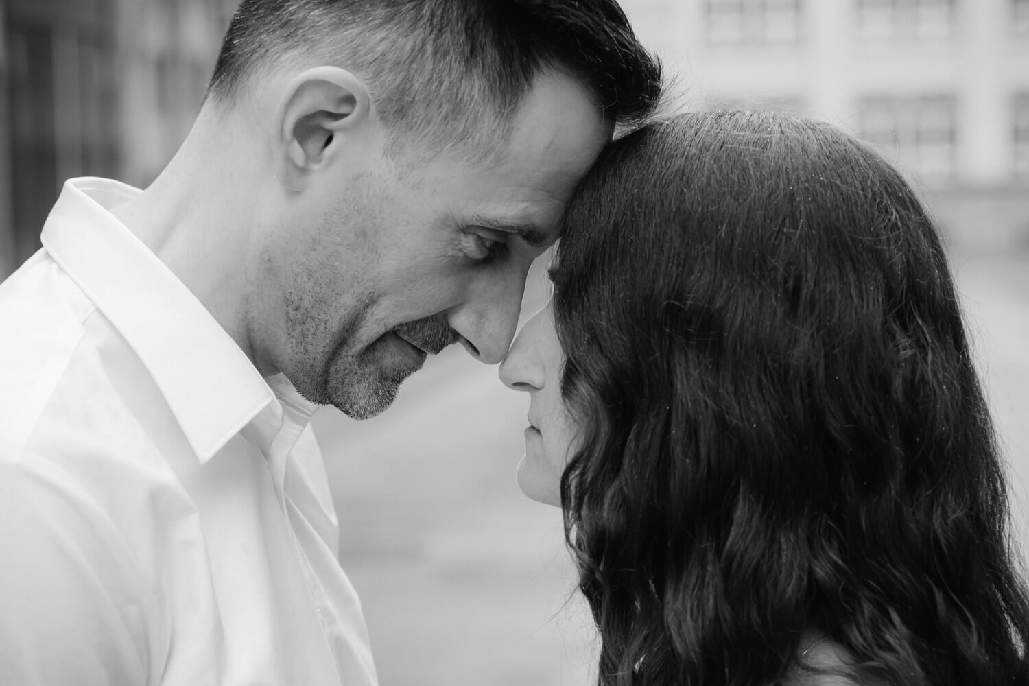 Paar steht Stirn an Stirn in ruhigem intimen Moment in Schwarzweiss